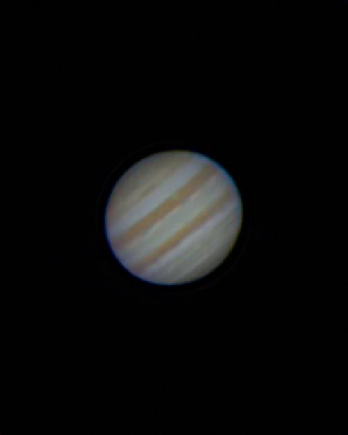 Jupiter as a small disc crossed by brown and cream cloud bands.